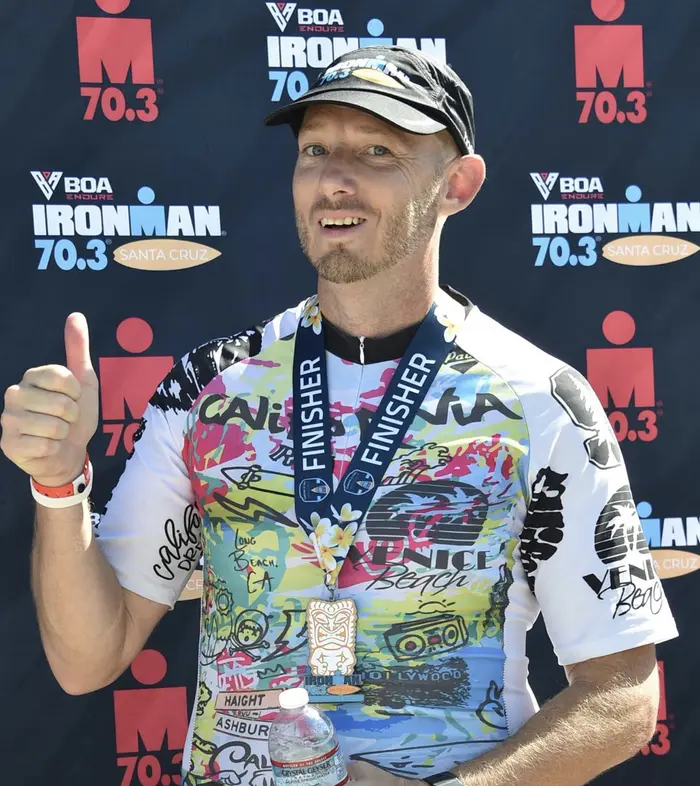 Bruce Franse wearing his Ironman 70.3 finisher medal